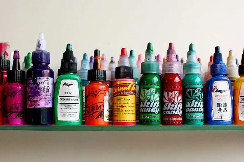 A shelf of coloured inks in a tattoo studio