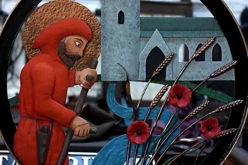 A painted village sign showing a figure working at a sluice