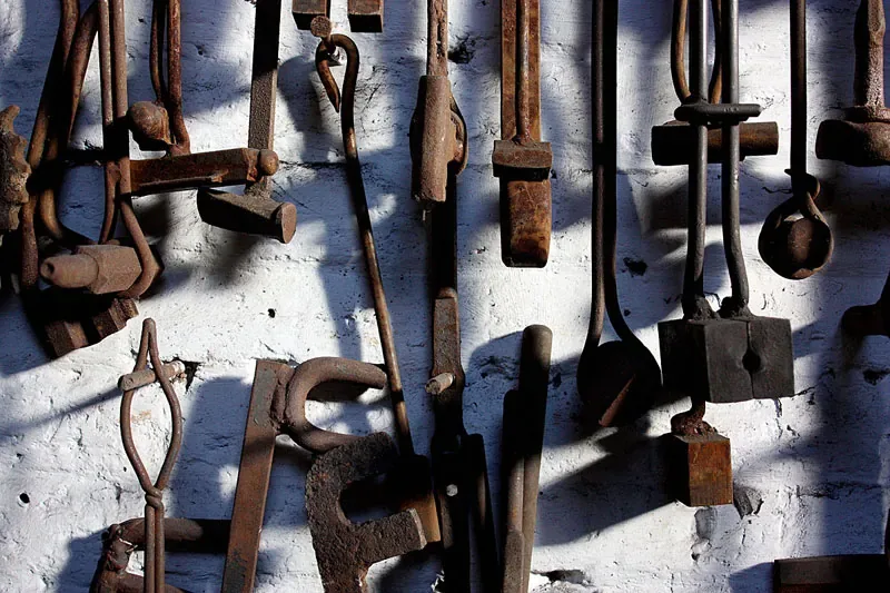Old hand tools hanging in rows on a workshop wall